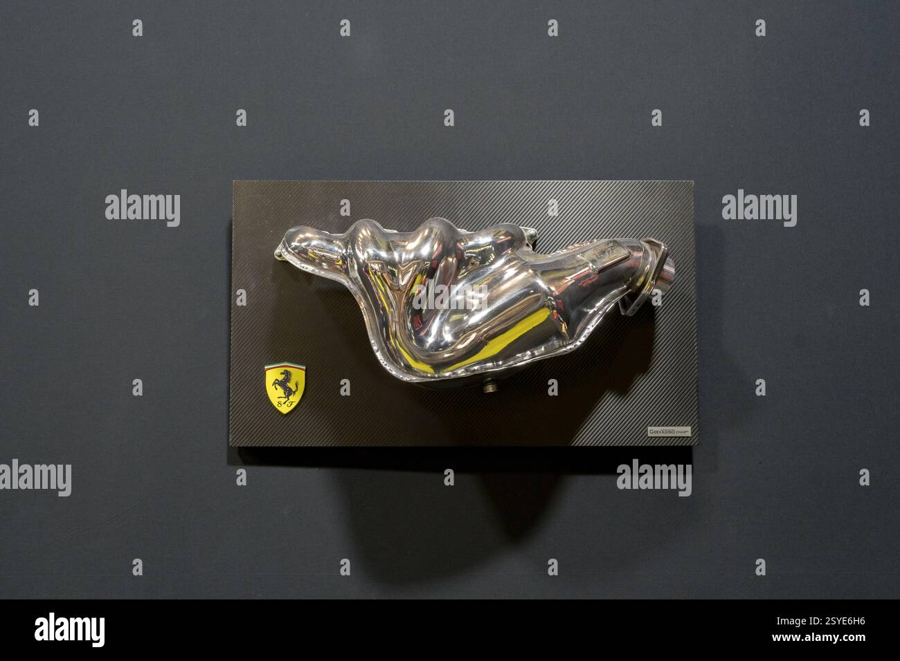 Einzigartige Darstellung eines polierten Metallteils eines klassischen italienischen Sportwagens vor einem eleganten schwarzen Hintergrund Stockfoto