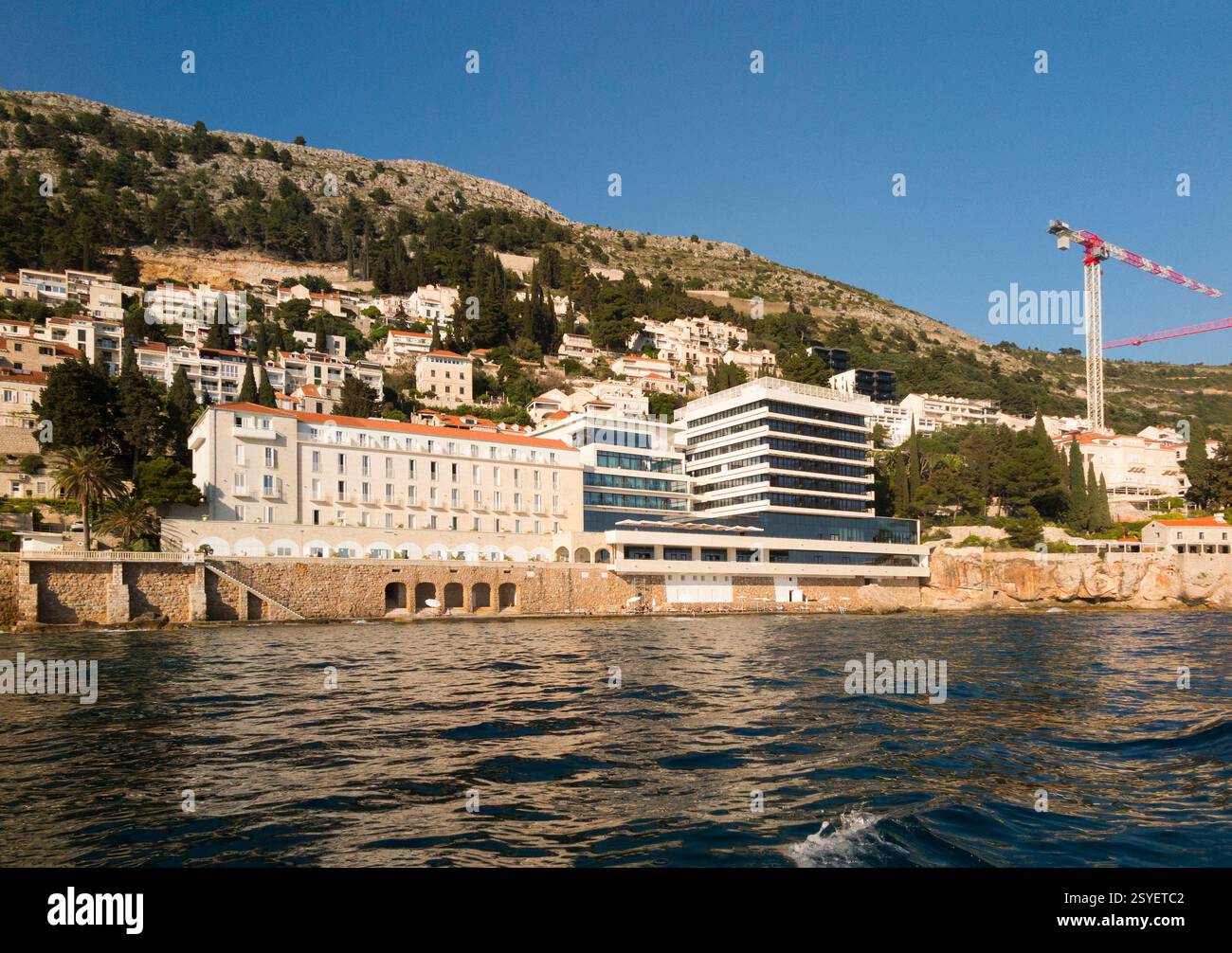Die entwickelte Küste/Küste ist nicht weit südöstlich der Altstadt, mit einem großen exklusiven Hotel, einschließlich des 5-Sterne-Hotels Excelsior, rechts, Dubrovnik. Kroatien. Gezeigt vom Meer an einem sonnigen Tag mit blauem Himmel an einem sonnigen Tag mit blauem Himmel. (138) Stockfoto