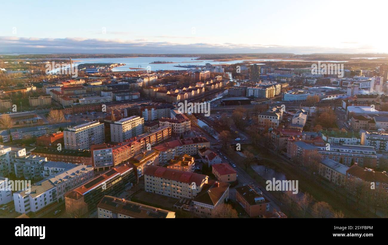 Ein atemberaubender Blick aus der Luft auf Karlstad, Schweden, bei Sonnenuntergang, mit einer malerischen Stadtlandschaft, Uferpromenade und goldenem Licht, das auf Gebäuden reflektiert, schafft eine friedliche und malerische Atmosphäre Stockfoto