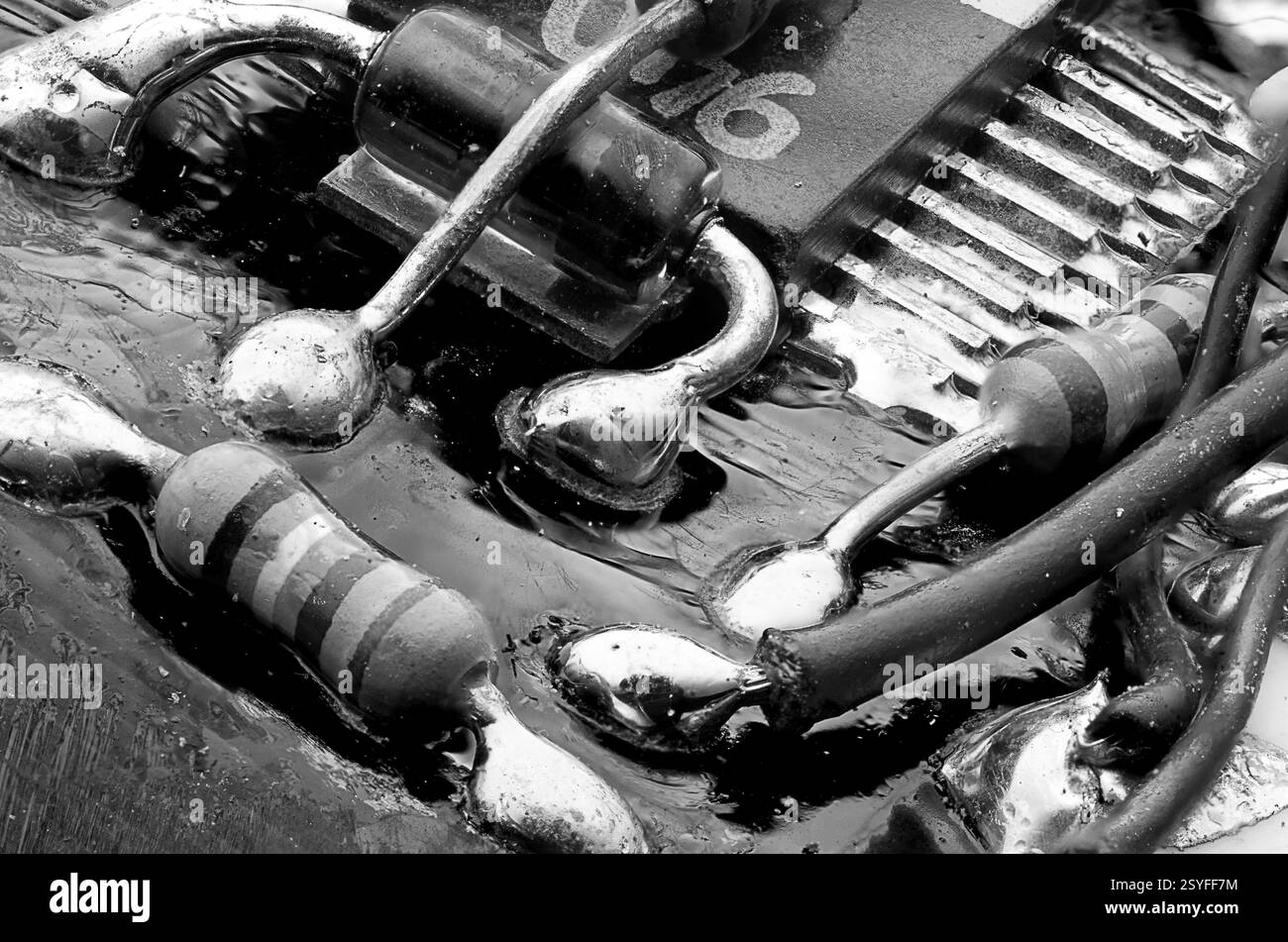 Makrofotografie einer Leiterplatte mit Lötanschlüssen, Widerständen und IC-Chip. Stockfoto