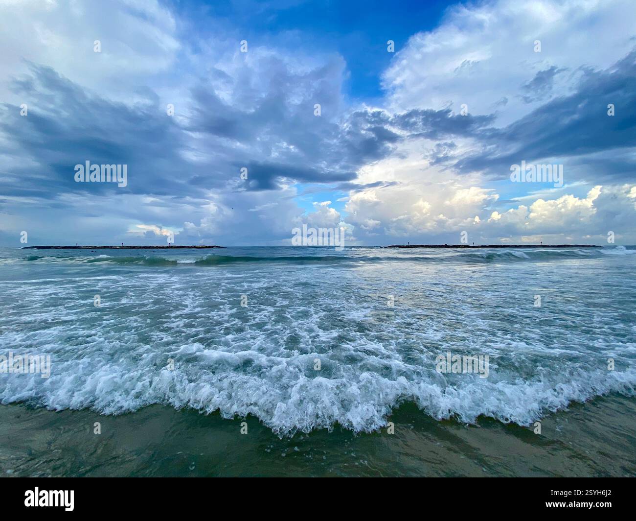 Ein malerischer Blick auf das Mittelmeer mit sanften Wellen und einem bewölkten Himmel an der Küste von Tel Aviv, Israel. - Smartphone-aufgenommenes Stockfoto