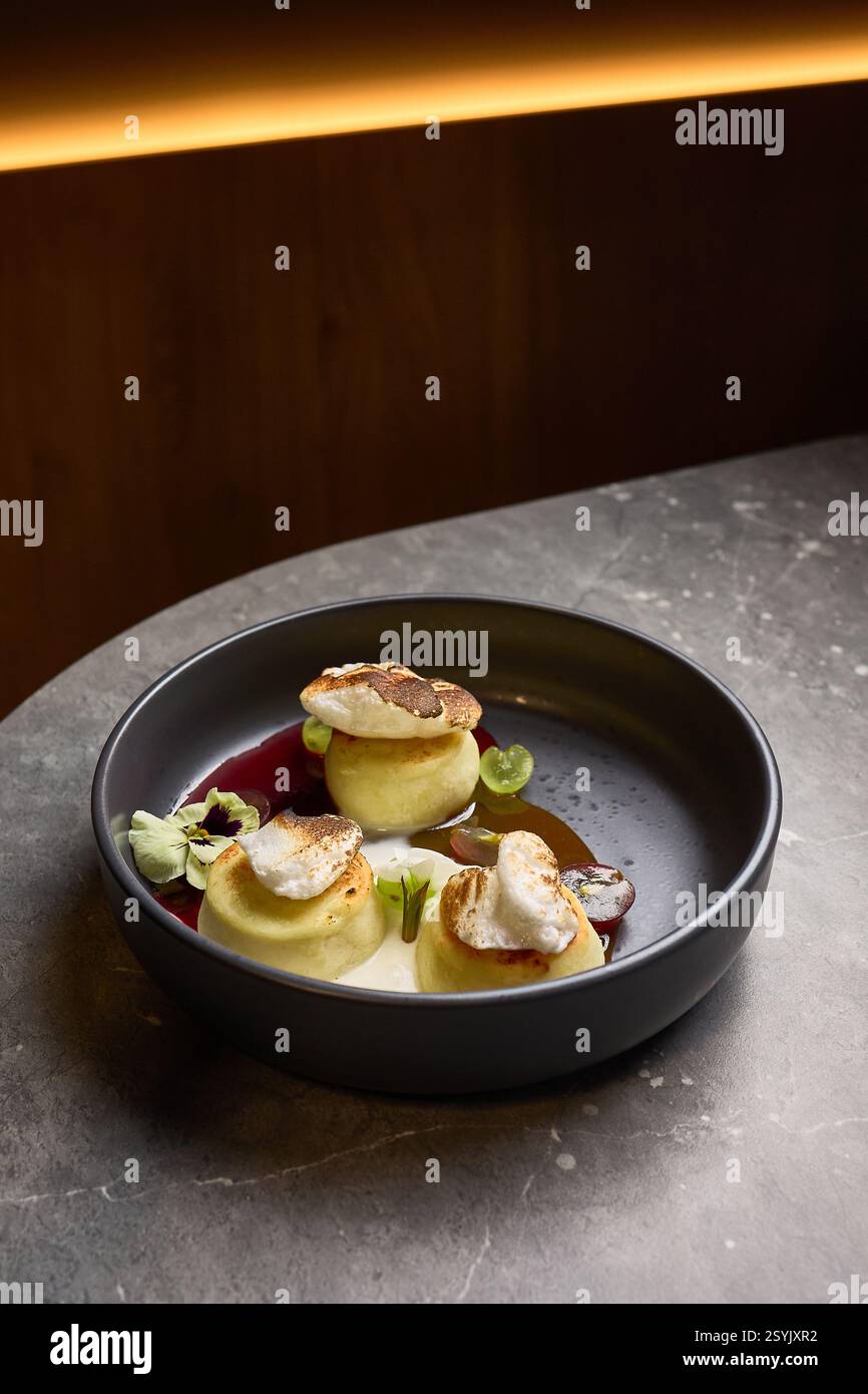 Käsekuchen Creme im Gourmet-Stil serviert, mit Karamell, frischen Beeren, auf einem eleganten Marmortisch, eine Dessert-Ästhetik, kulinarische Präsentation c Stockfoto