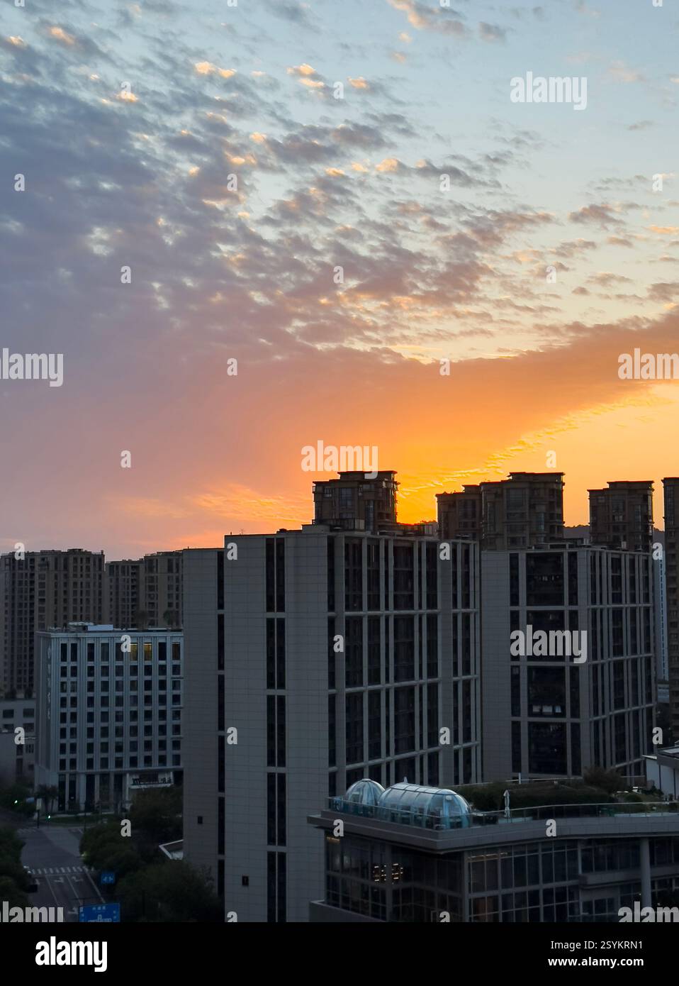Lebendiger Sonnenuntergang, der die Skyline der Stadt mit modernen Gebäuden im Abendlicht beleuchtet Stockfoto