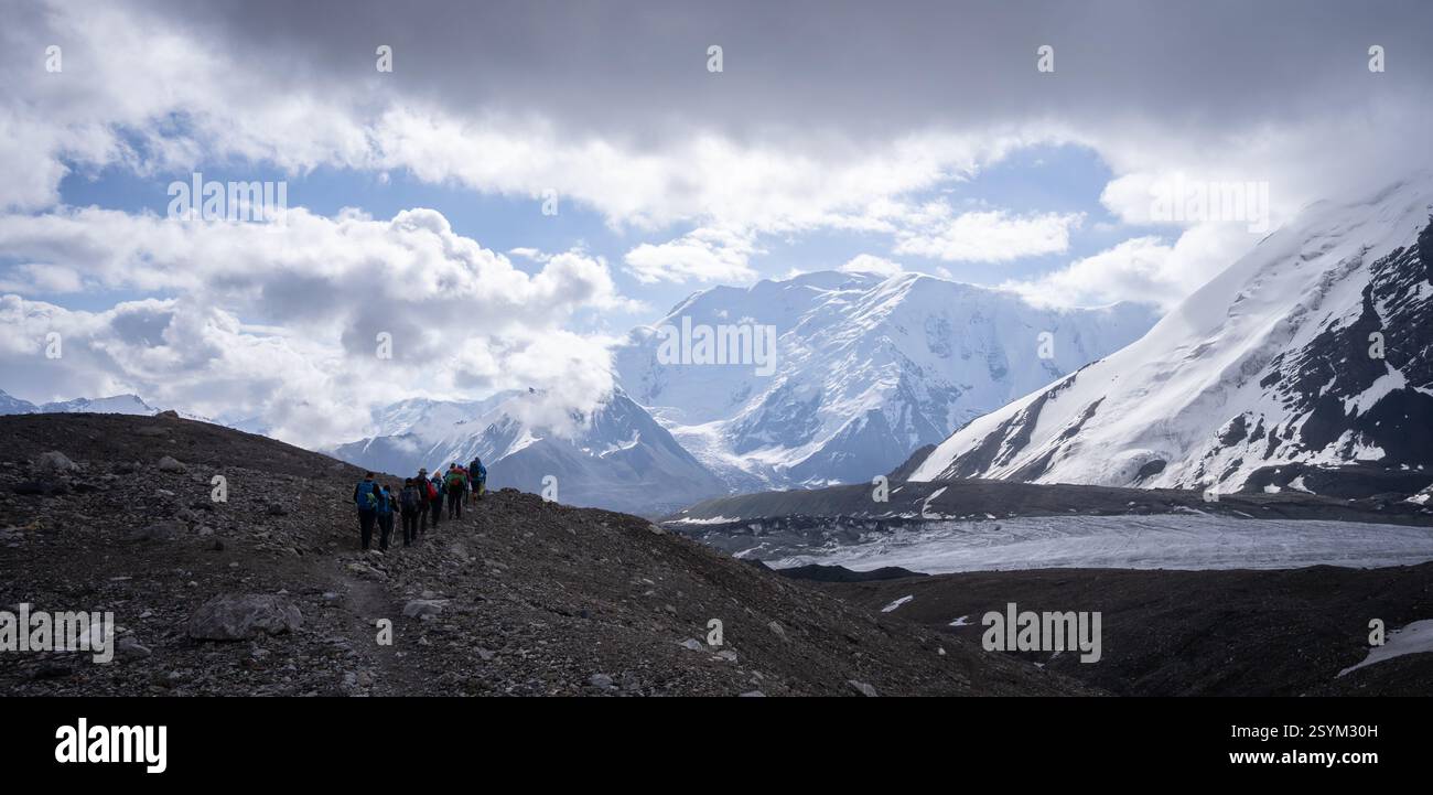 Gruppe von Wanderern, die durch die alpine Gletscherlandschaft im Pamir-Gebirge in Kirgisistan spazieren Stockfoto