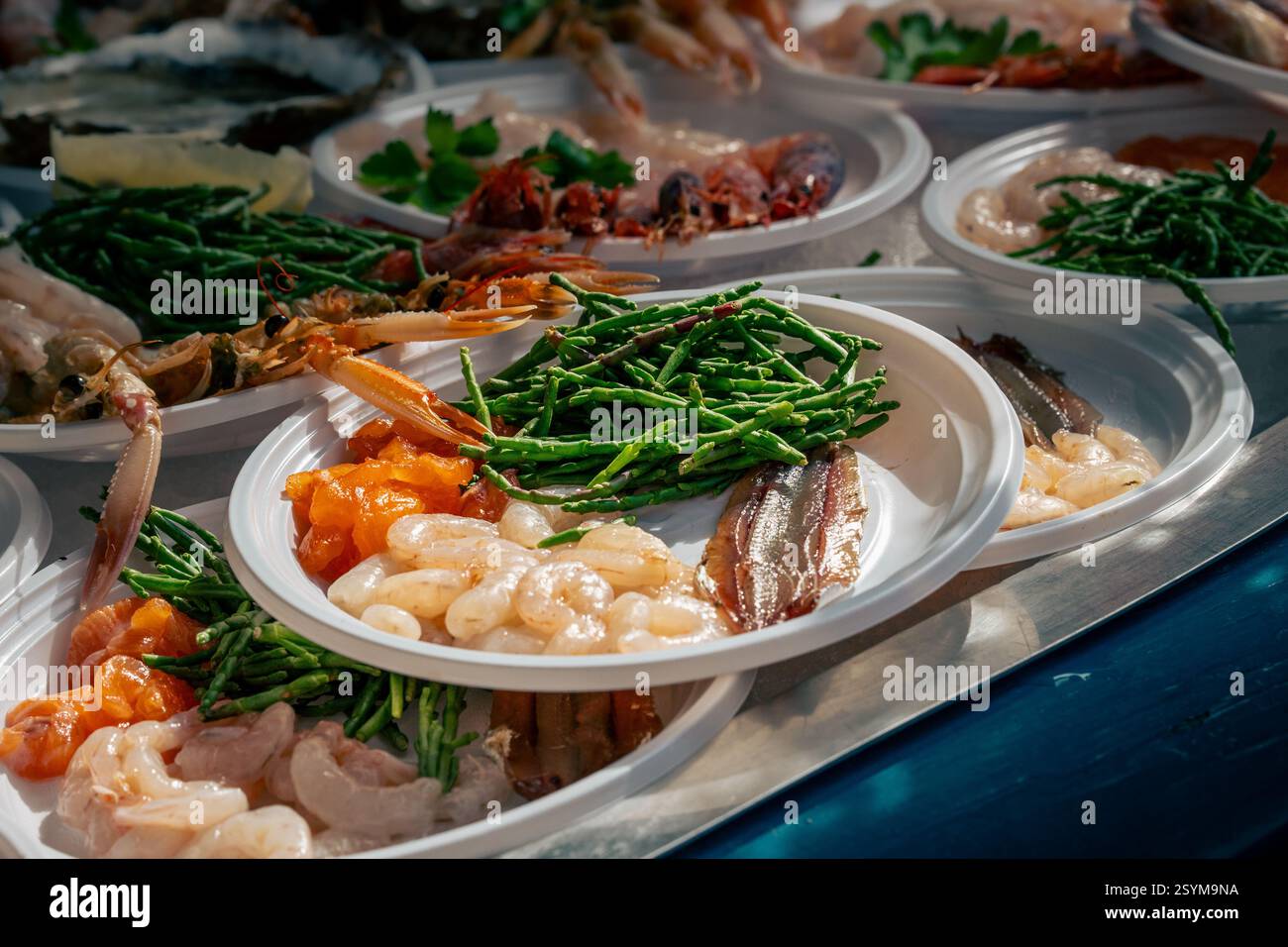 Auf Catanias Fischmarkt werden frische Meeresfrüchte angeboten, mit mariniertem rohem Fisch, Garnelen, Sardellen und Seespargel auf Tellern. Authentische Stree Stockfoto