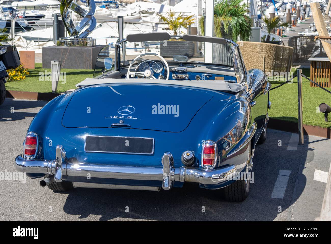 Klassischer blauer mercedes benz 190 sl Oldtimer in einem luxuriösen Yachthafen, der Raffinesse und Automobilgeschichte verkörpert Stockfoto