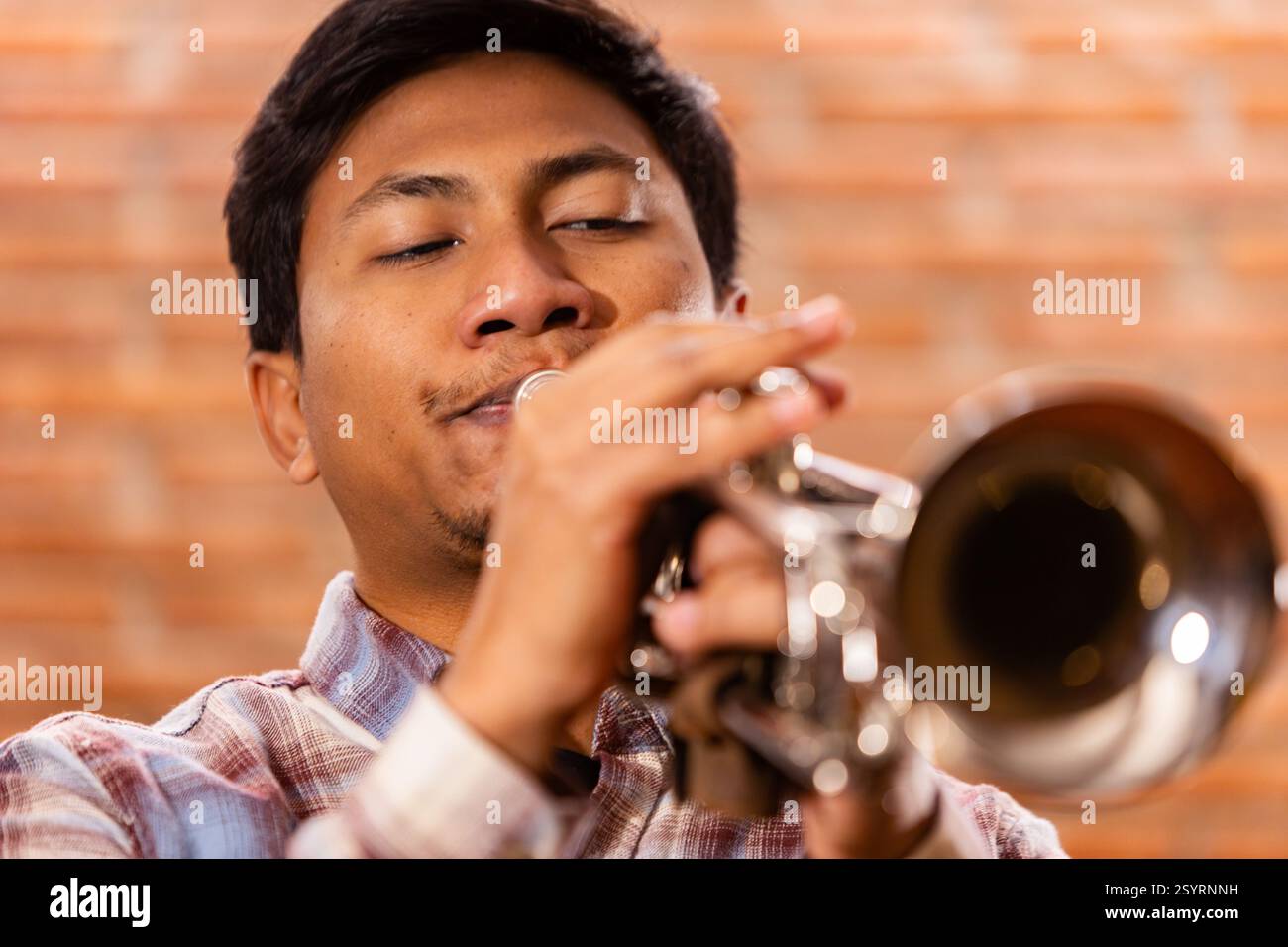 Nahaufnahme eines leidenschaftlichen Trompetenspielers, der in Musik eingetaucht ist. Lifestyle. Stockfoto