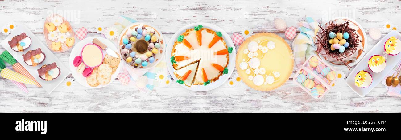 Ostern oder Frühling Dessert Esstisch Tisch Szene. Draufsicht über einem weißen Holzbanner Hintergrund. Zitronentorte, Cupcakes, Osterei und Karottenkuchen und ein Asso Stockfoto