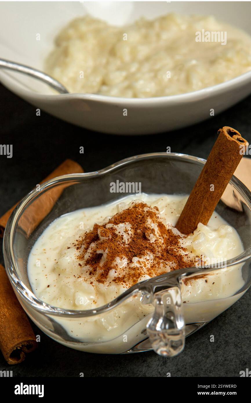 Traditionelles brasilianisches Dessert aus Reis und Kondensmilch, genannt Arroz Doce, dekoriert mit Zimt auf dunklem Hintergrund Stockfoto