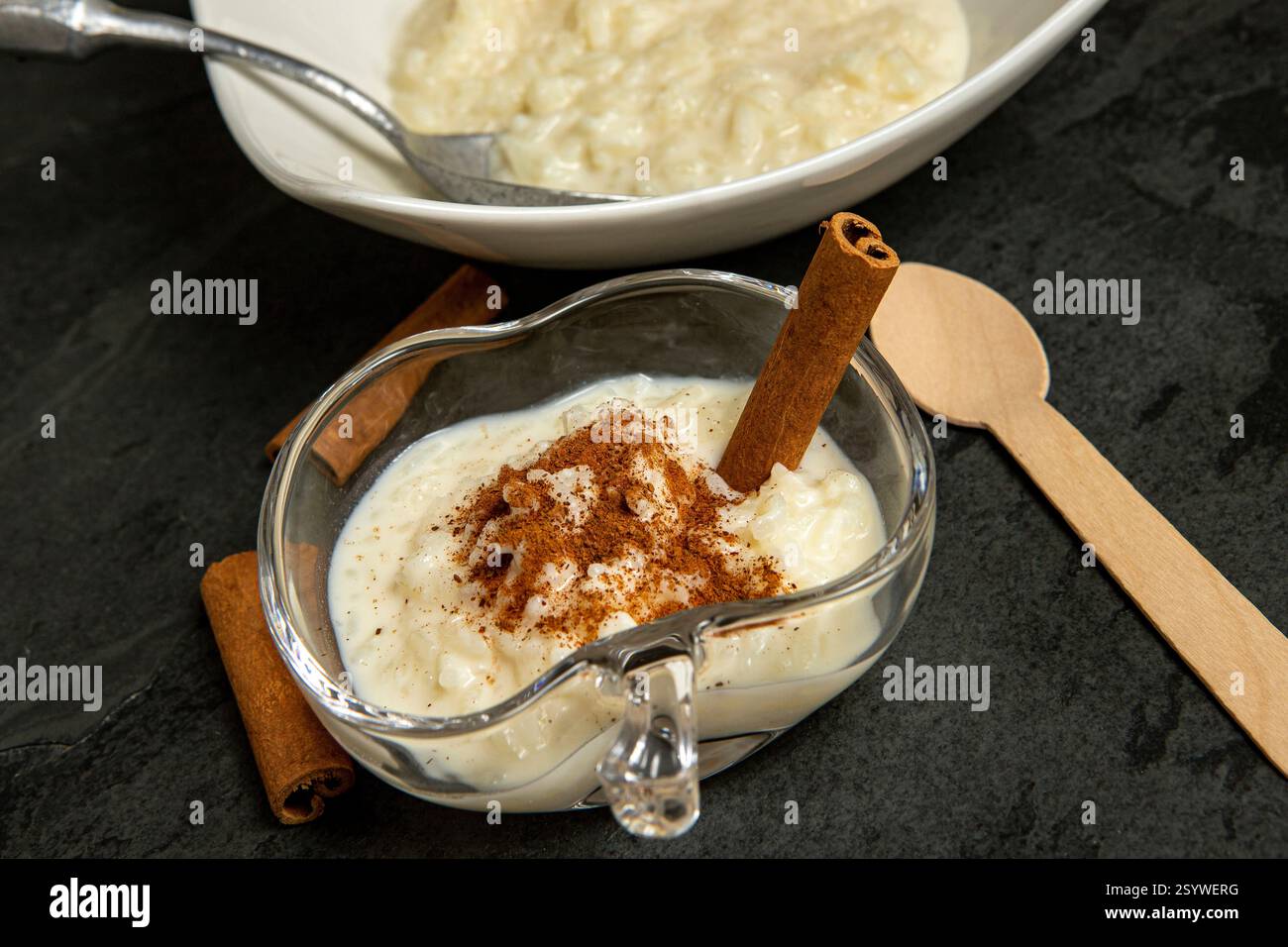 Traditionelles brasilianisches Dessert aus Reis und Kondensmilch, genannt Arroz Doce, dekoriert mit Zimt auf dunklem Hintergrund Stockfoto