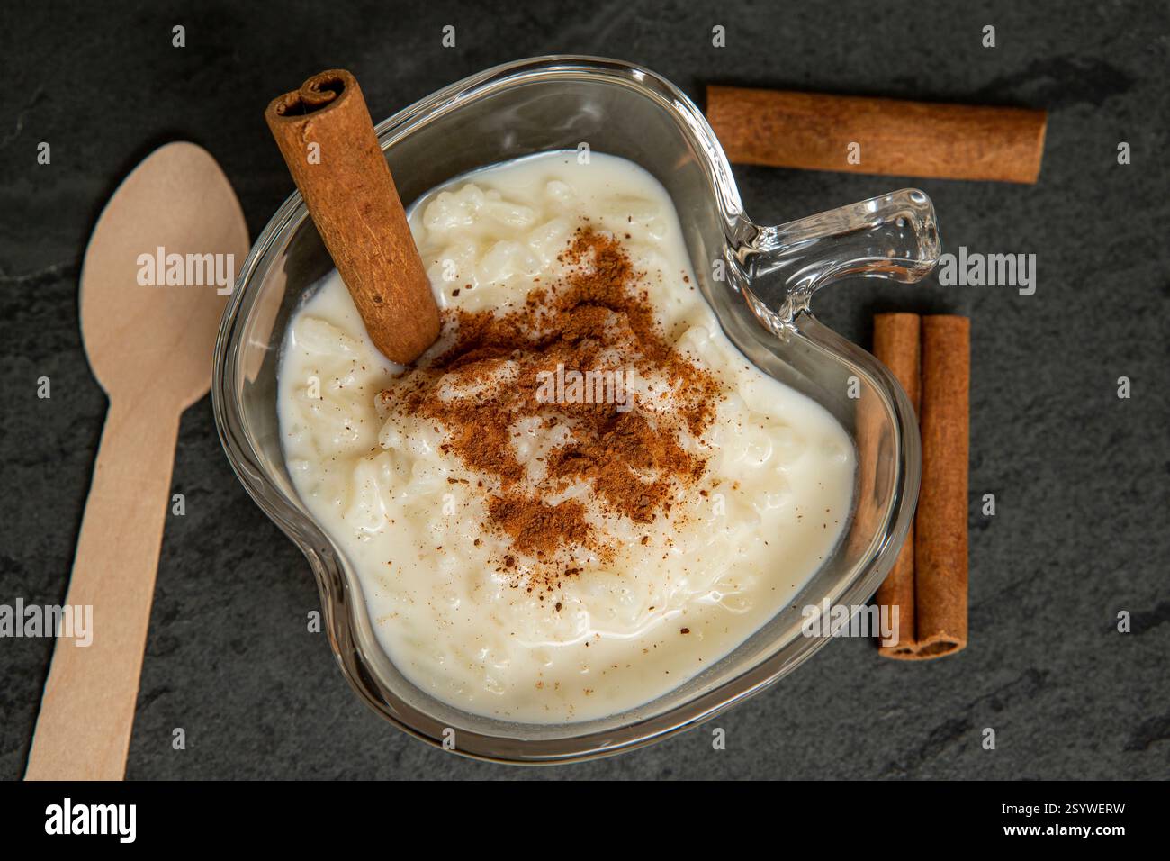 Traditionelles brasilianisches Dessert aus Reis und Kondensmilch, genannt Arroz Doce, dekoriert mit Zimt auf dunklem Hintergrund Stockfoto