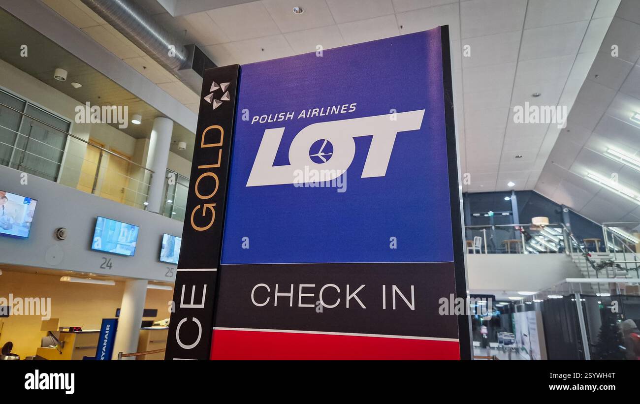 Tallinn, Estland - 3. Dezember 2024: LOT Polish Airlines Gold Check-in-Schild am Flughafenterminal. Stockfoto