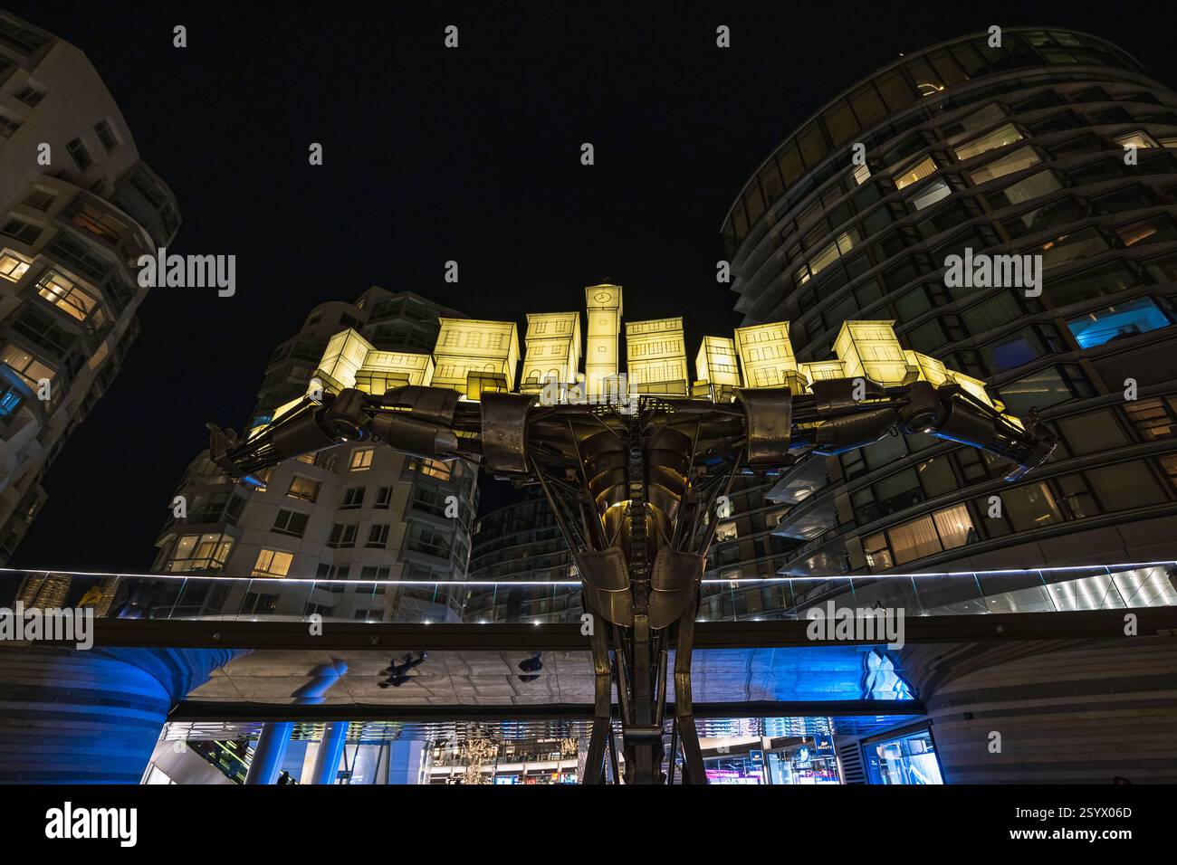 „Atlas“, ein mechanischer Cyborg, der eine beleuchtete Stadt von Jon Voss unterstützt, wird während des jährlichen Lichtfestivals der Battersea Power Station in London gezeigt. Stockfoto