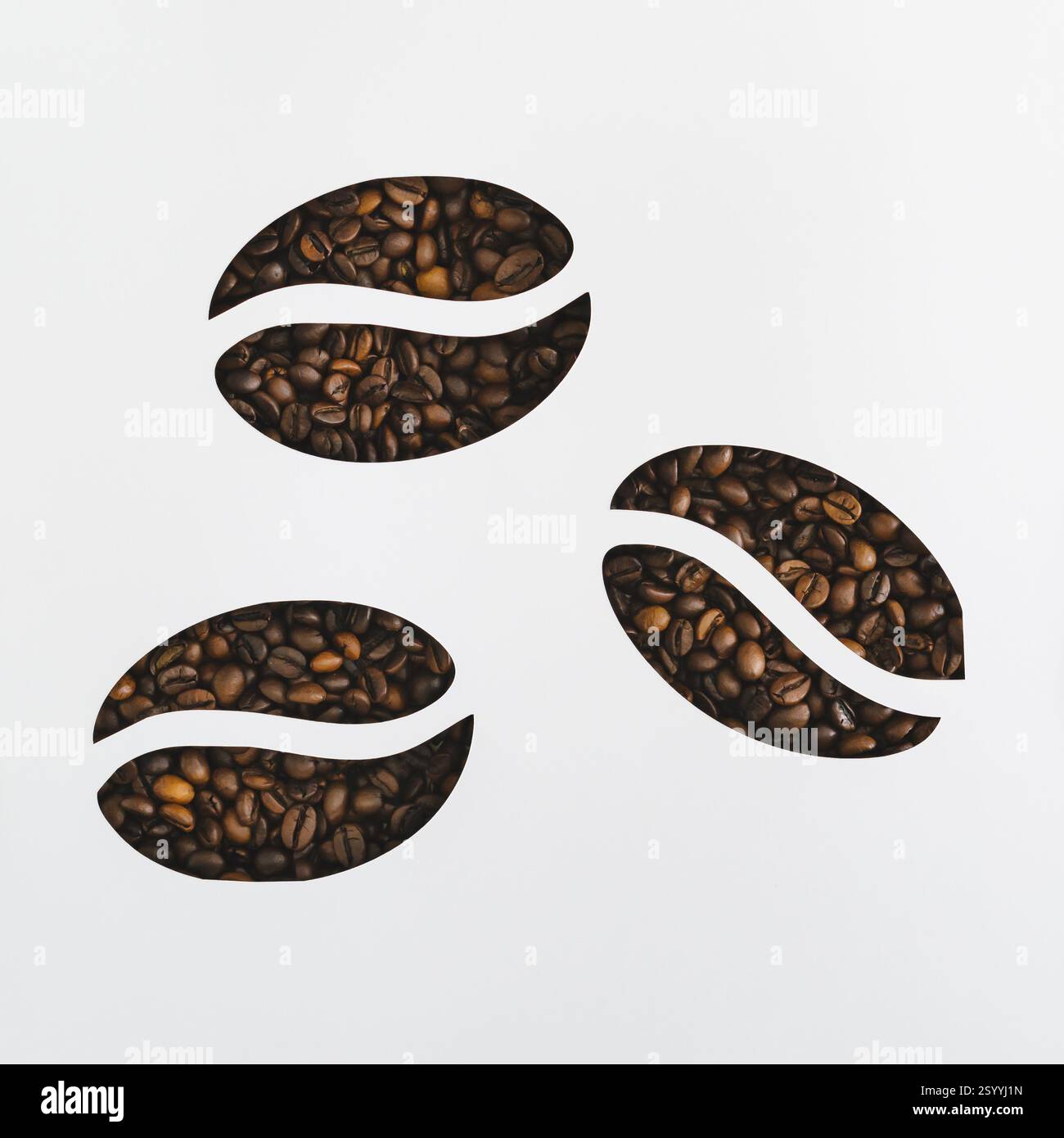 Kaffeebohnen sichtbar durch Kaffeebohnen geformte Lücken auf weißem Hintergrund. Minimales Konzept. Kaffeeästhetik. Flaches, Draufsicht-Banner. Stockfoto