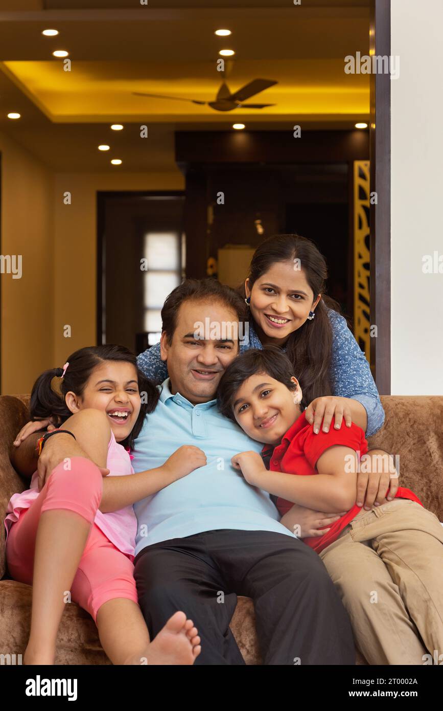 Porträt einer glücklichen Mittelklasse-Familie, die zu Hause im Wohnzimmer genießt Stockfoto