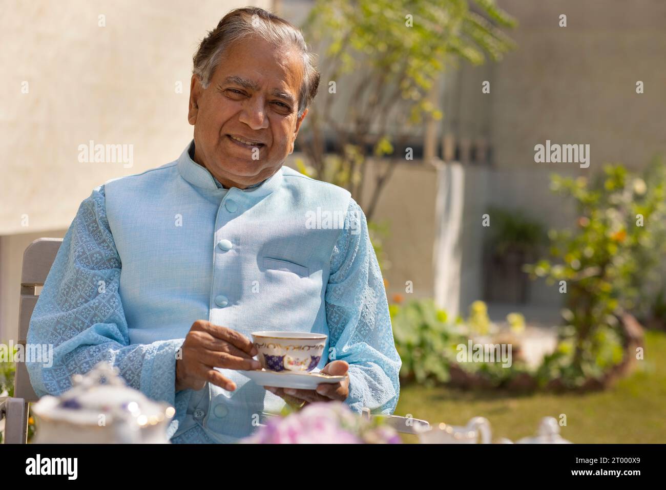 Porträt eines älteren Mannes, der Tee im Garten trinkt Stockfoto