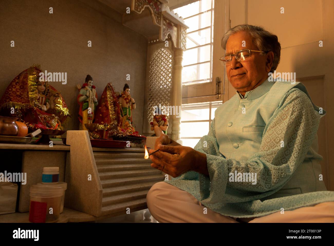 Porträt eines älteren Mannes, der zu Hause pooja des hinduistischen Gottes spielt Stockfoto