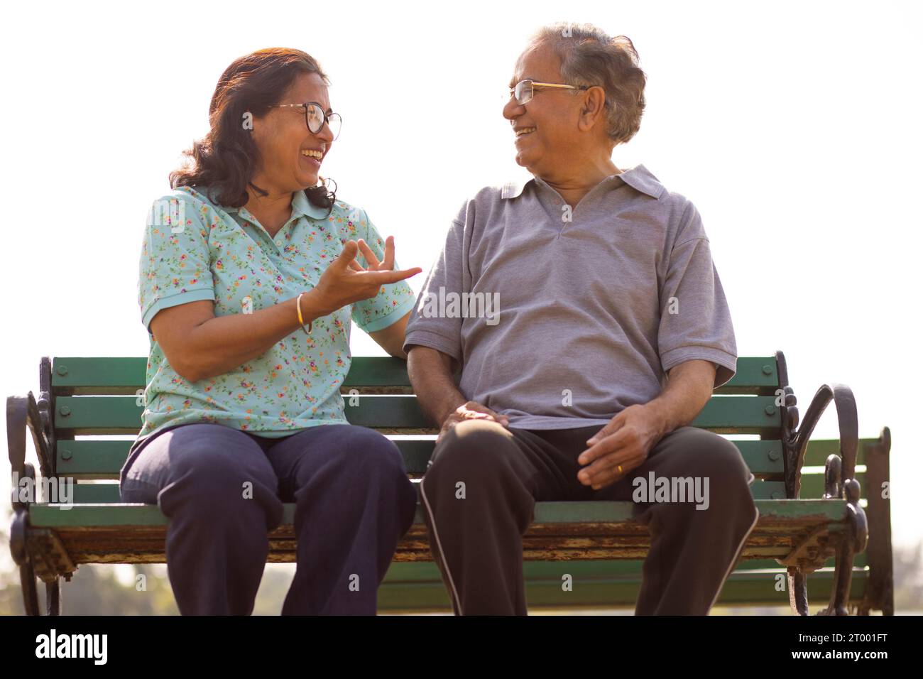 Glückliches Älteres Ehepaar sitzt zusammen auf einer Bank im öffentlichen Park Stockfoto