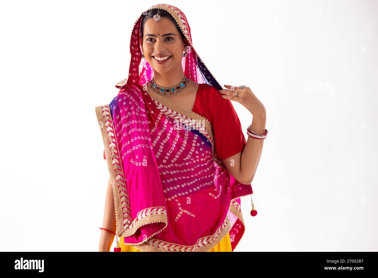 Porträt einer Rajasthani-Frau im Sari, die vor weißem Hintergrund steht Stockfoto
