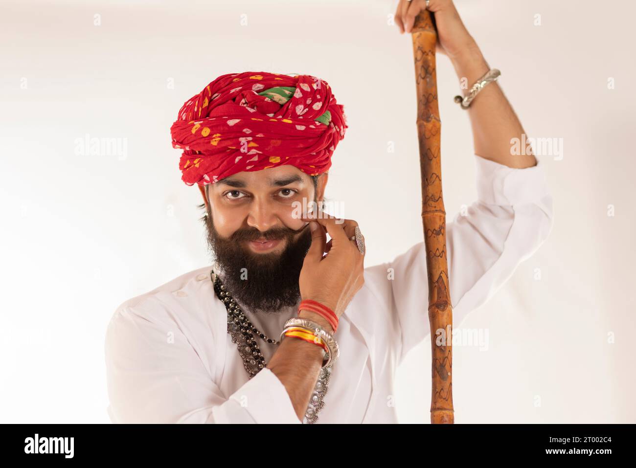 Nahporträt eines jungen Rajasthani-Mannes, der vor weißem Hintergrund steht Stockfoto