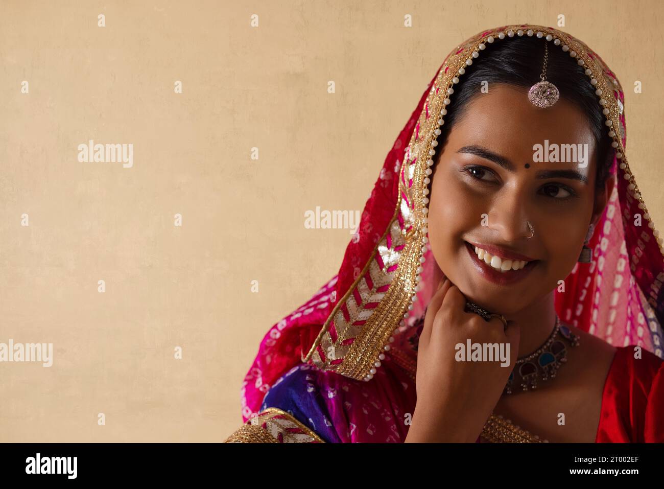 Nahporträt einer fröhlichen jungen Rajasthani-Frau vor klarem Hintergrund Stockfoto