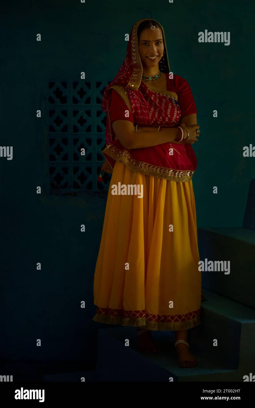 Rajasthani-Frau, die mit gefalteten Händen auf der Treppe steht Stockfoto