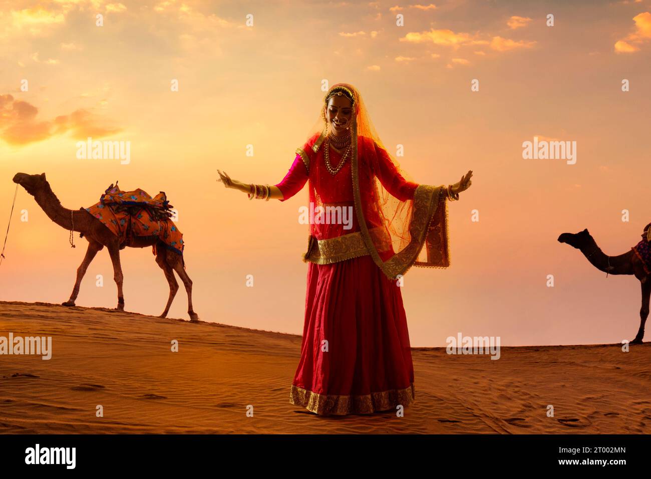 Rajasthani-Frau tanzt bei Sonnenuntergang in der Wüste Stockfoto