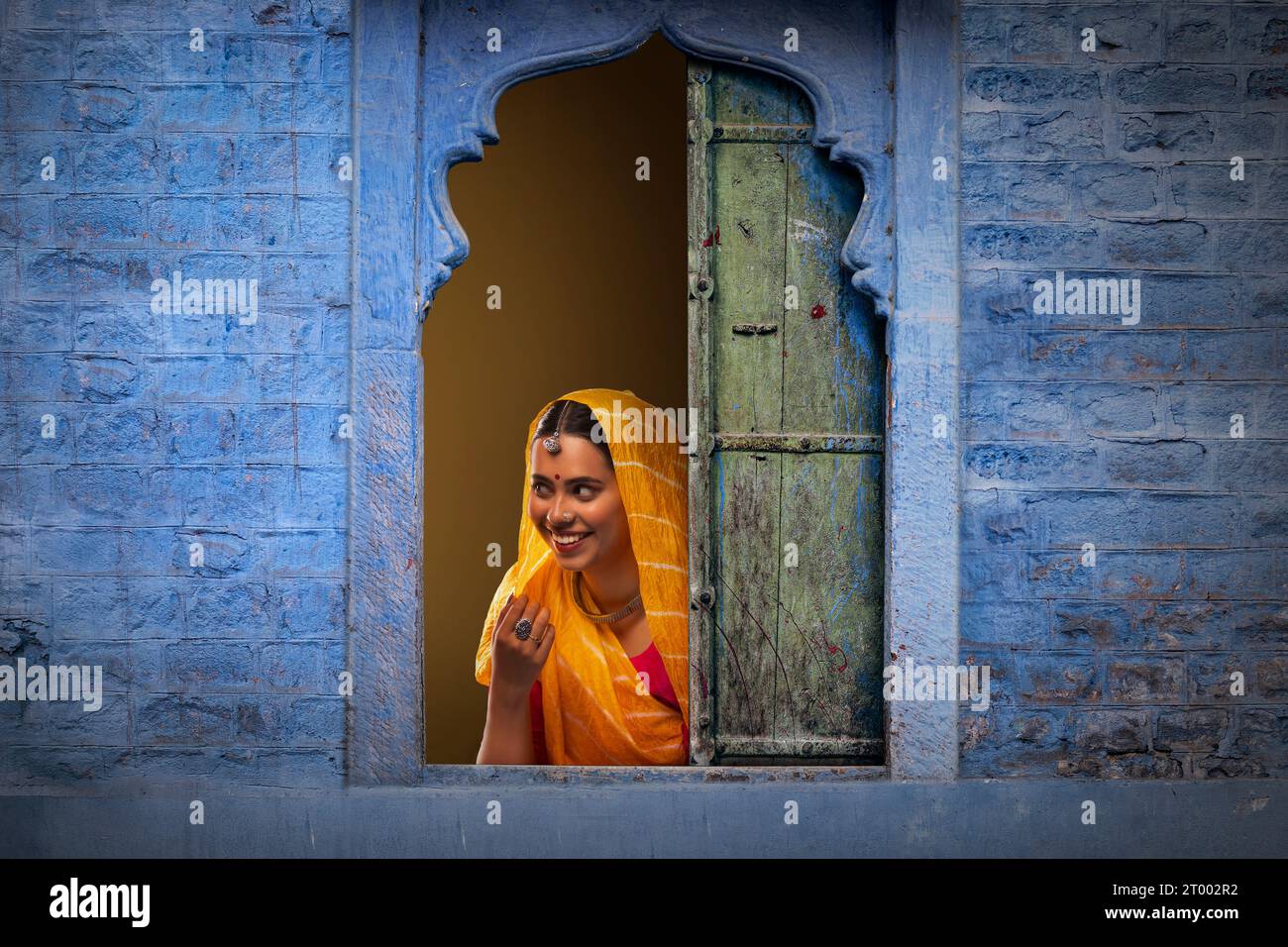 Rajasthani, junge Frau, die durch das Fenster guckt Stockfoto