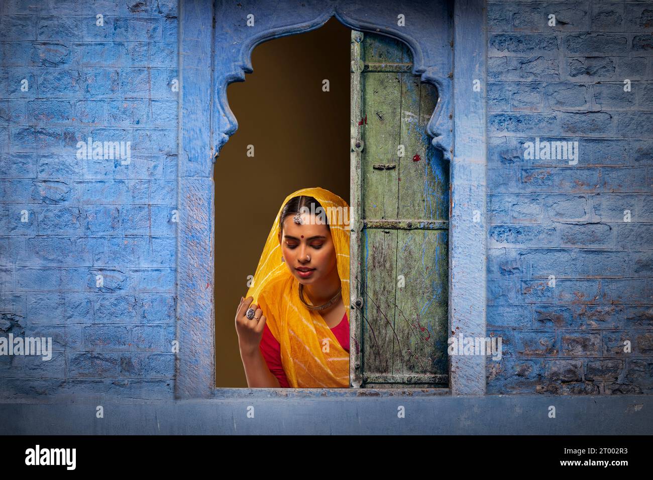 Rajasthani, junge Frau, die durch das Fenster guckt Stockfoto