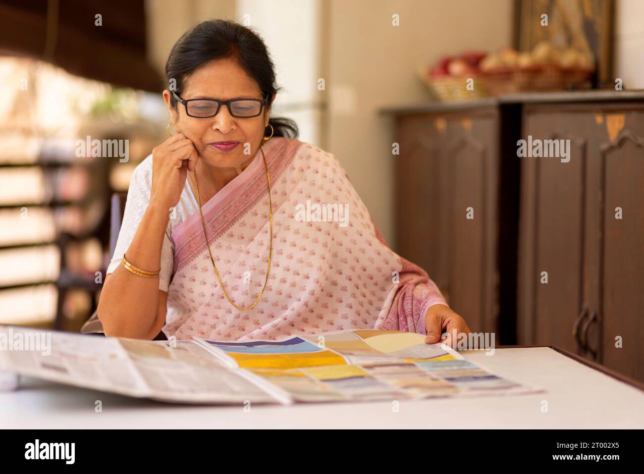 Porträt einer älteren Frau, die Zeitung liest Stockfoto