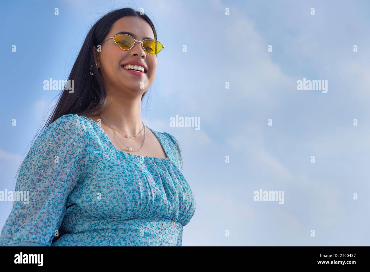 Porträt junger Frauen mit Sonnenbrille vor blauem Himmel Stockfoto