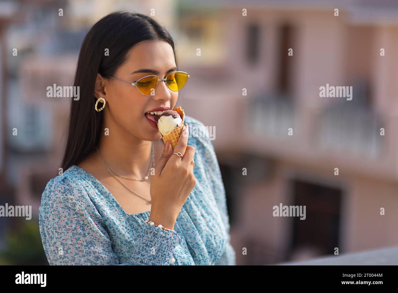 Porträt einer jungen Frau, die Eis im Kegel isst Stockfoto