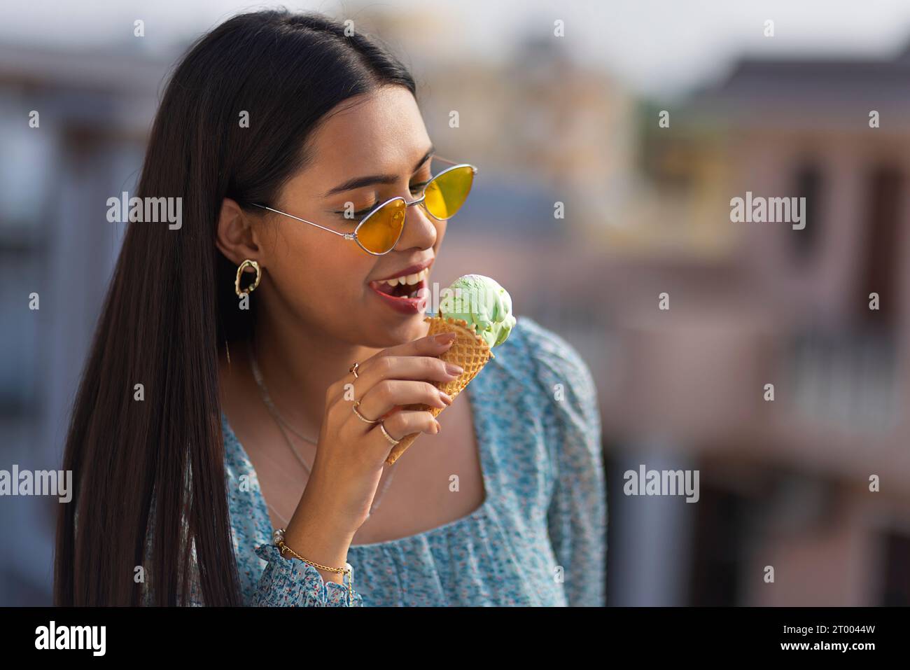 Porträt einer jungen Frau, die Eis im Kegel isst Stockfoto