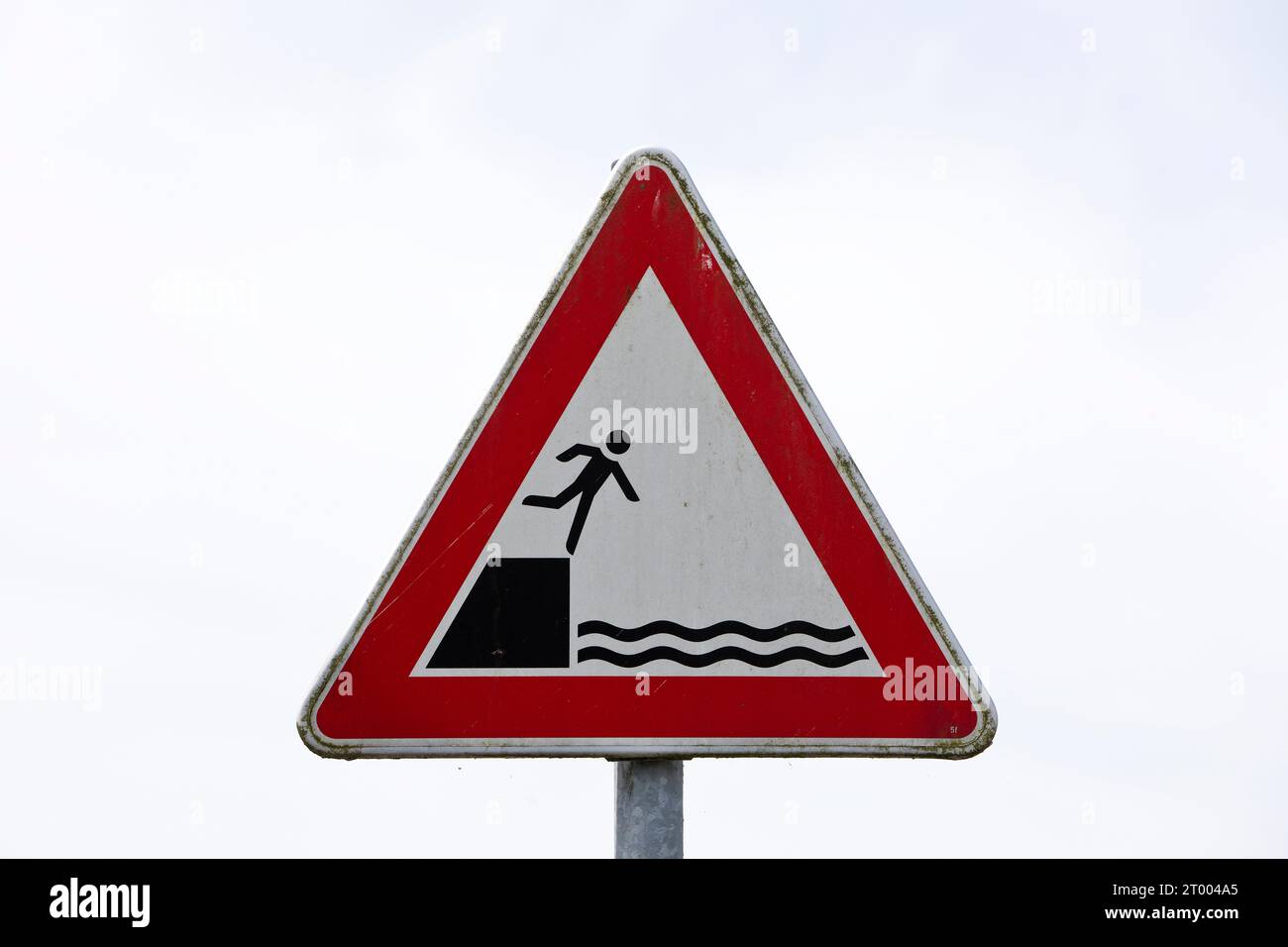 Ein Schild warnt die Menschen, nicht vom Rand ins Wasser zu fallen, in den Hafen, leer, Deutschland, Europa Stockfoto