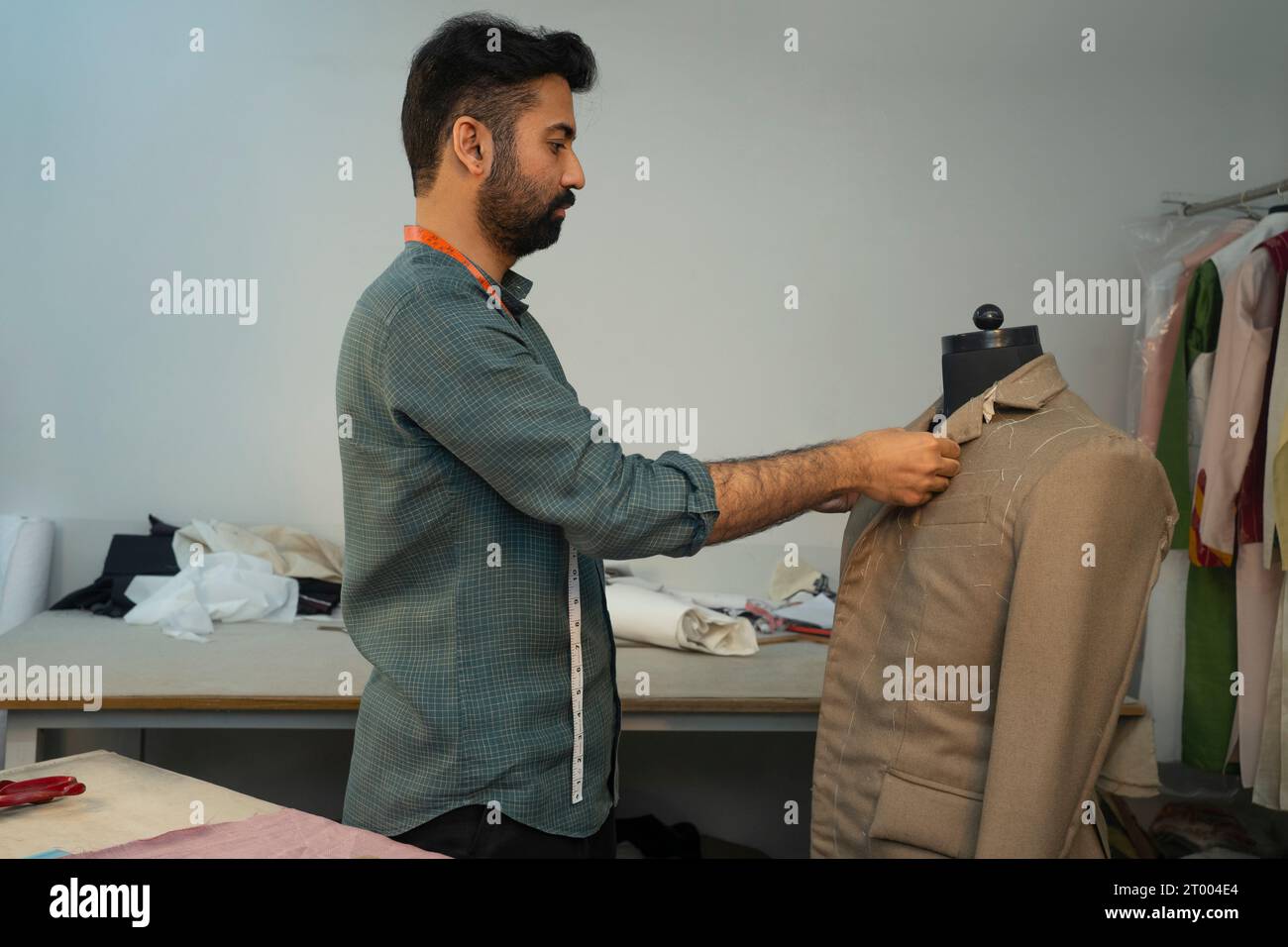 Herrenmode Designer arbeitet an einer maßgeschneiderten Jacke in seinem Studio Stockfoto