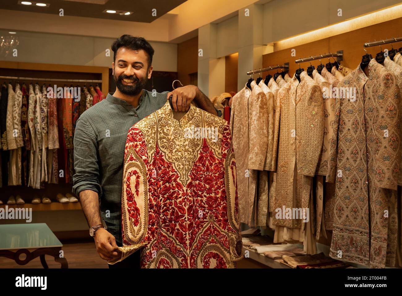 Käufer versucht indische Kleidung in einem Bekleidungsgeschäft Stockfoto