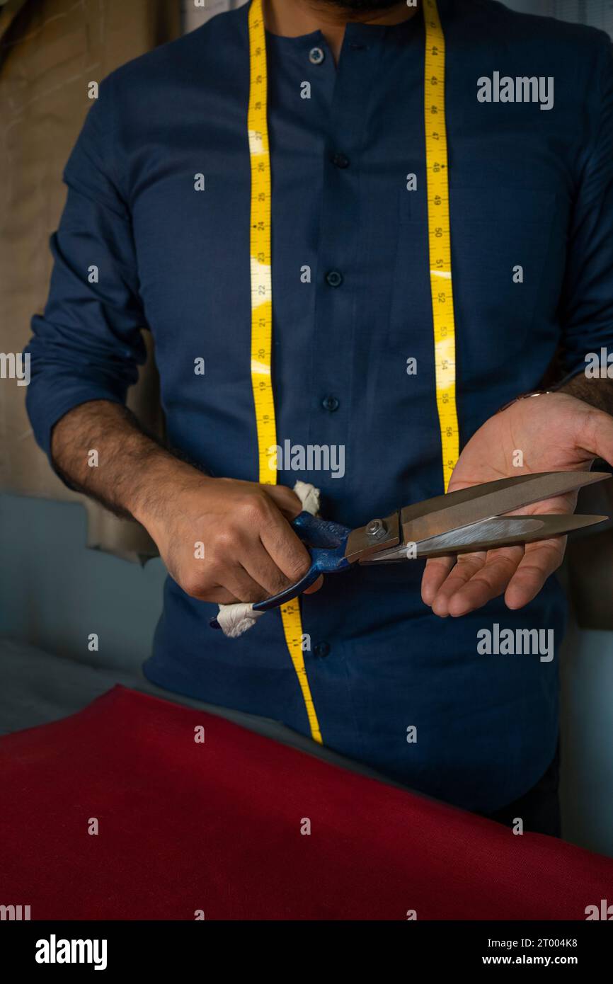 Ein maßgeschneiderter Schneider zeigt sein Werkzeug - eine Stoffschere Stockfoto