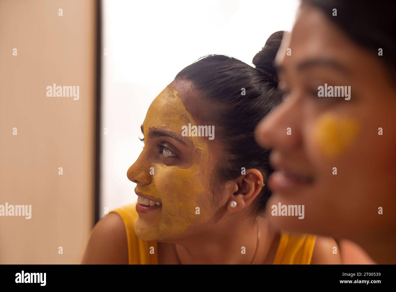 Nahaufnahme von zwei Frauen mit Kurkuma-Gesichtspack Stockfoto