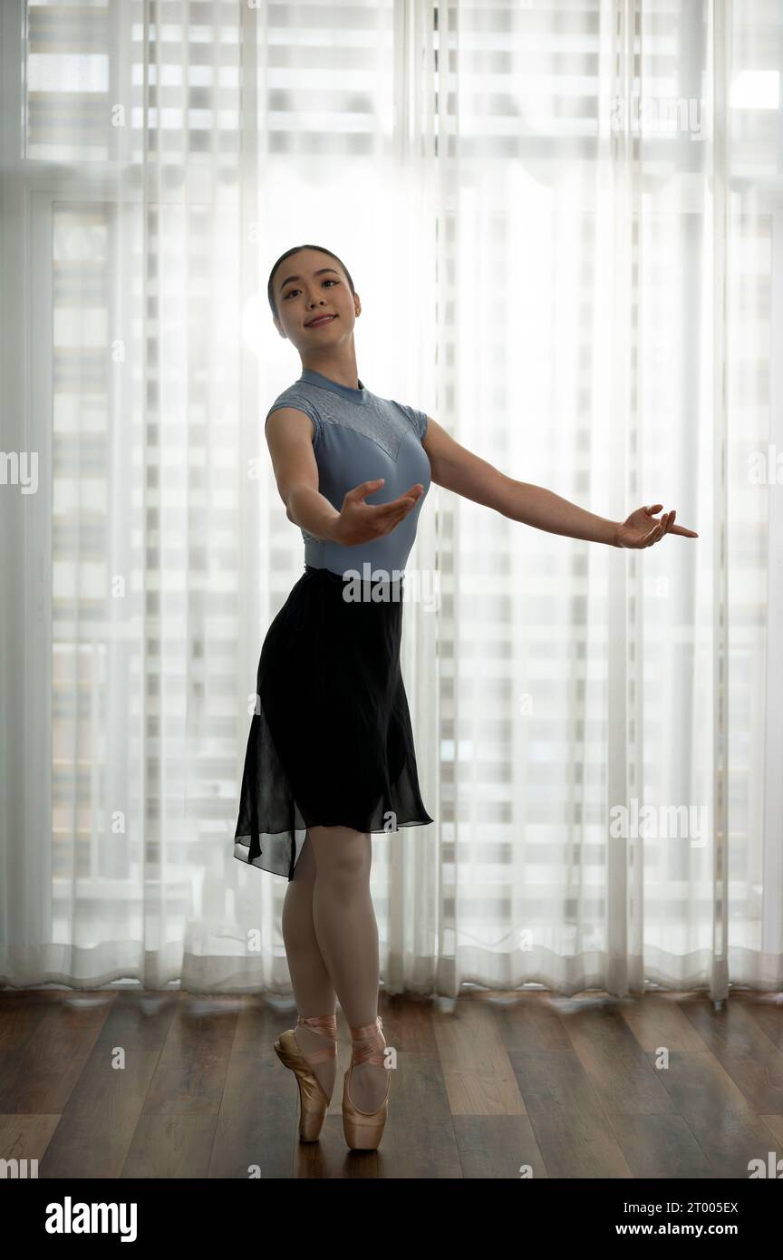 Ein junges Mädchen übt Balletttanz in einer modernen Wohnung. Junge Ballerina, die klassische Choreographie praktiziert. Ballettkonzept. Stockfoto
