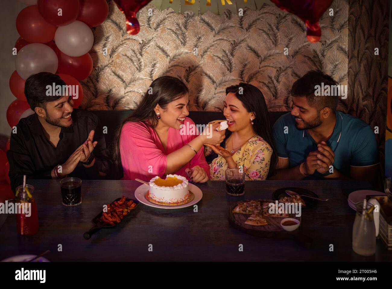 Freunde feiern Geburtstag ihres Freundes im Restaurant Stockfoto