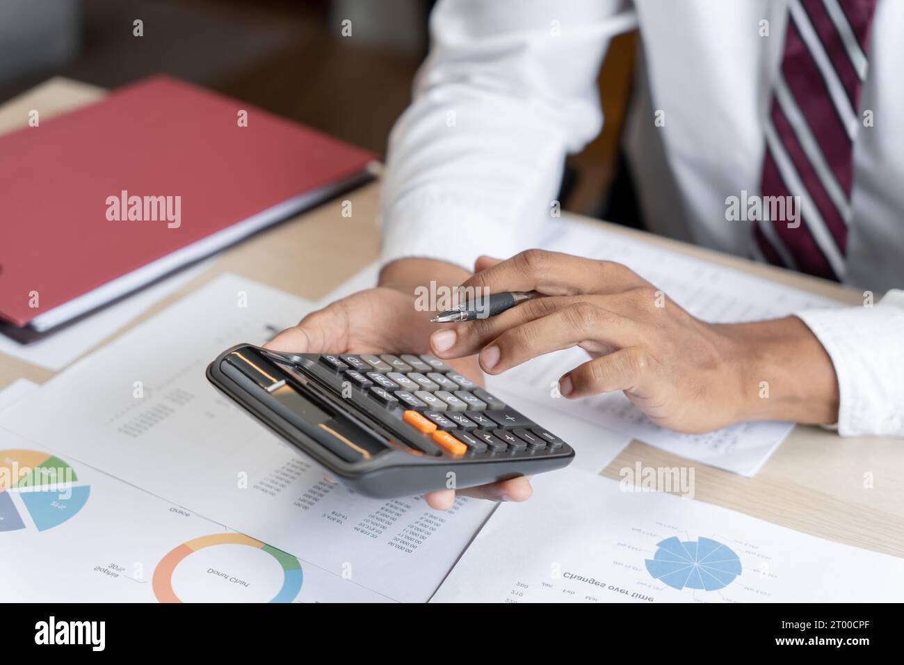 Geschäftsmann Buchhalter Analyse von Investitionsdiagrammen Rechnung und Drücken von Rechnerschaltflächen über Dokumenten. Buchhalter Stockfoto