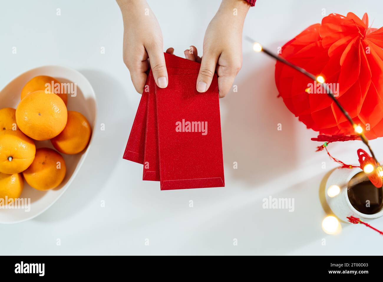 Asiatische Frau gibt roten Umschlag für das Neujahrsfest. Handgriff, rotes Paket Stockfoto