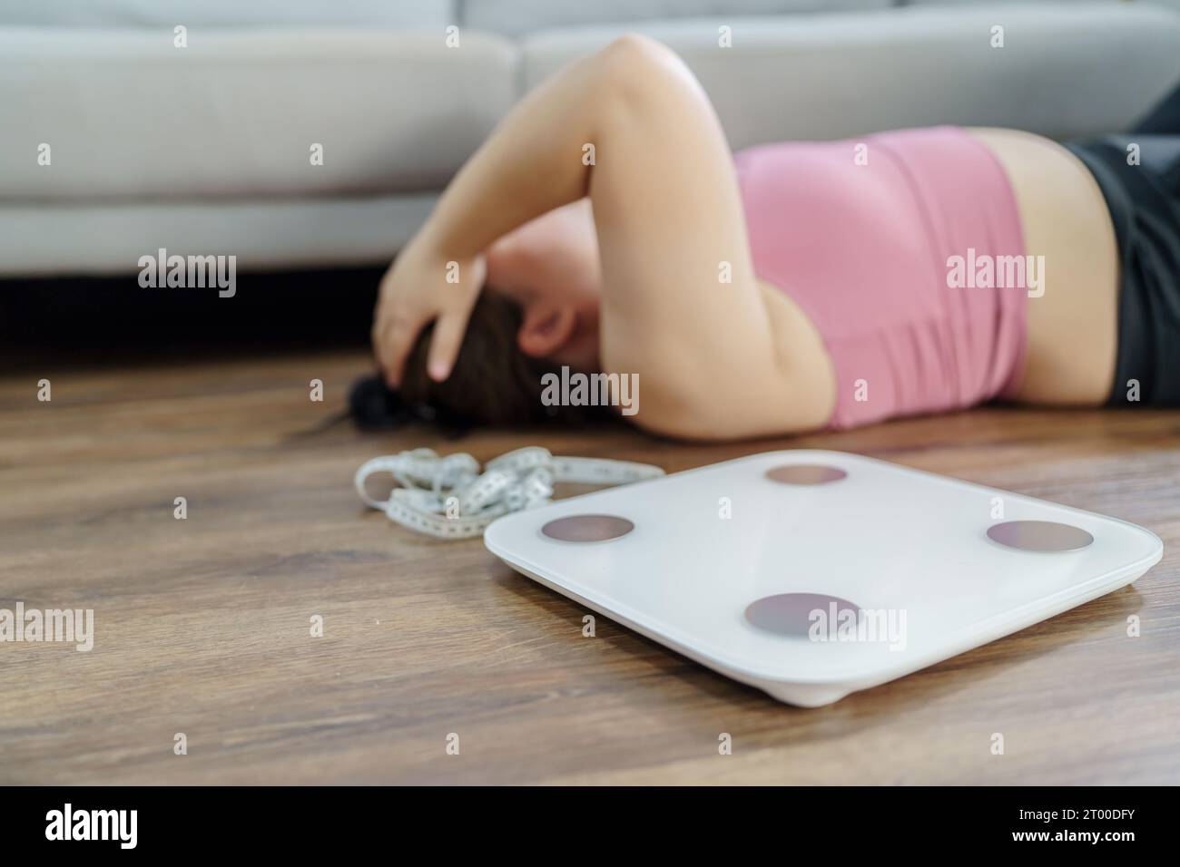 Fettleibige Frau mit Fett gestört gelangweilt von Diät Gewichtsverlust failÂ Fett Diät und Waage traurige asiatische Frau auf Gewichtswaage zu Hause Gewicht Stockfoto
