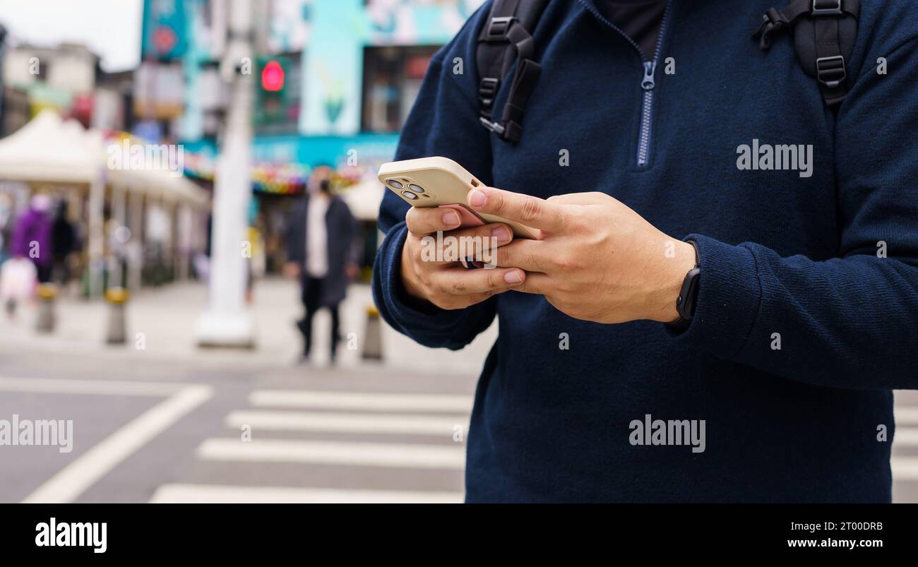 Mann in Downtown City Street, der Taxi mit Smartphone App bestellt, Taxi mit App online auf Smartphone gebucht Stockfoto