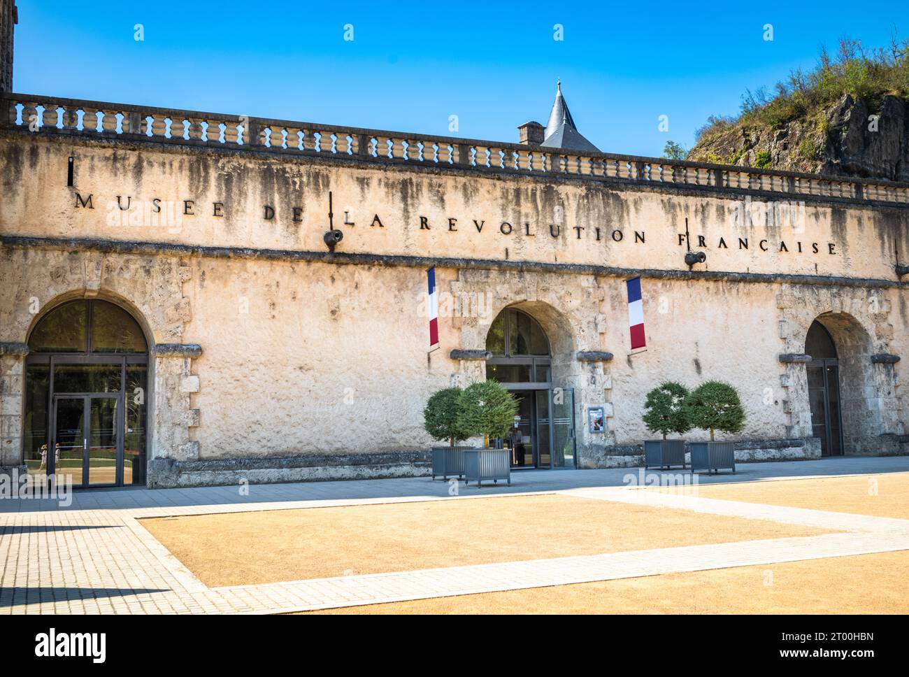 Neben den Haupttüren des Schlosses, in dem sich das Museum der Französischen Revolution in Vizille, Frankreich befindet, fliegen französische Fahnen. Stockfoto