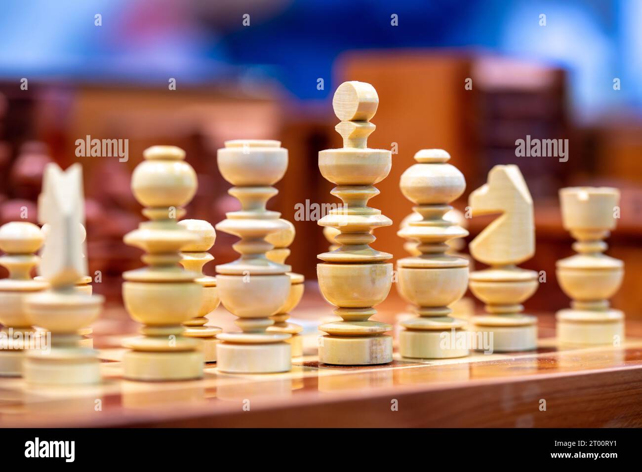 Weiße hölzerne Schachfiguren fotografiert von der Seite mit farbenfrohem Hintergrund Stockfoto