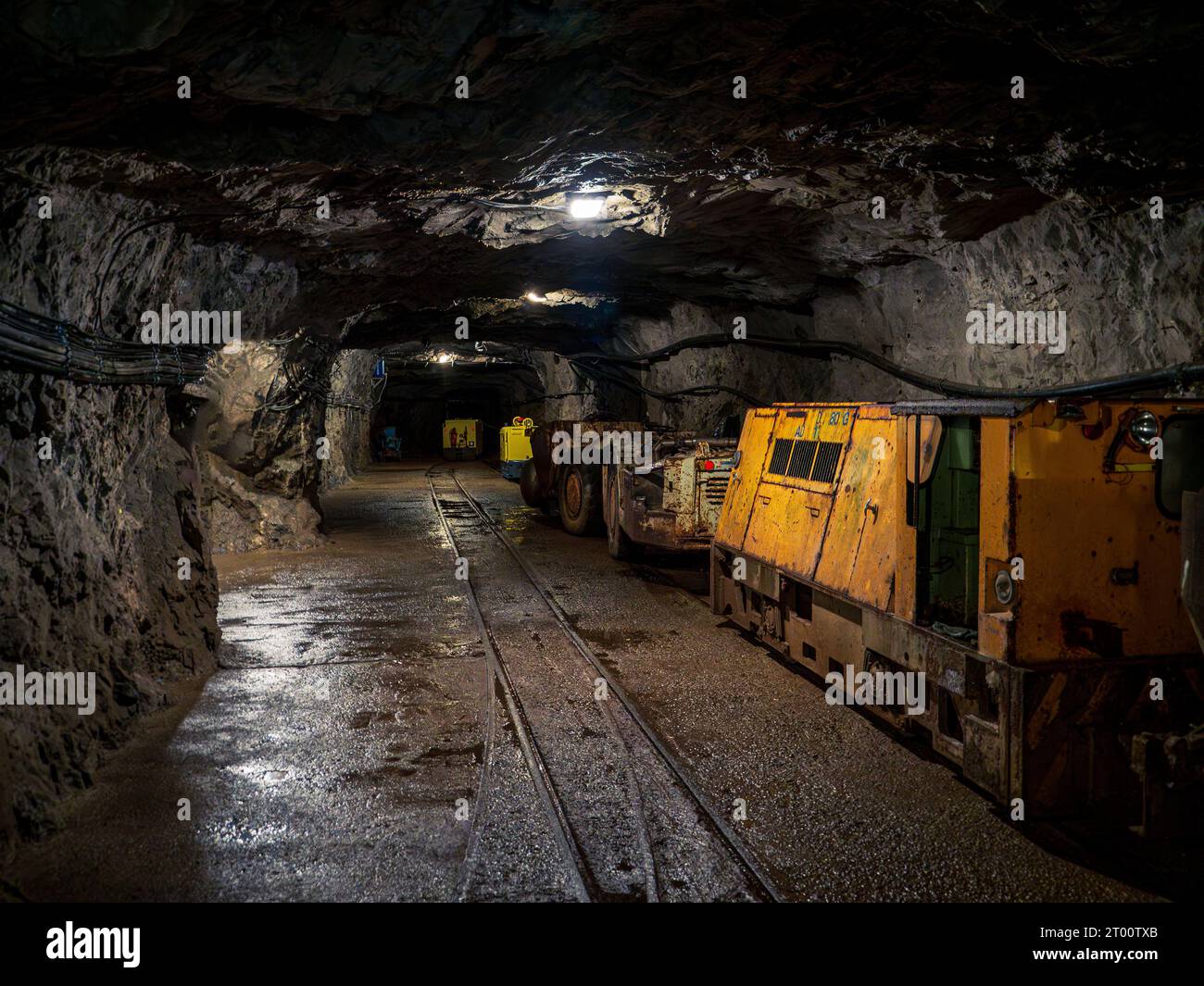 Bergbaugeräte trainieren die gelben Traktormaschinen in einem unterirdischen Kohlebergbau-Tunnel Stockfoto