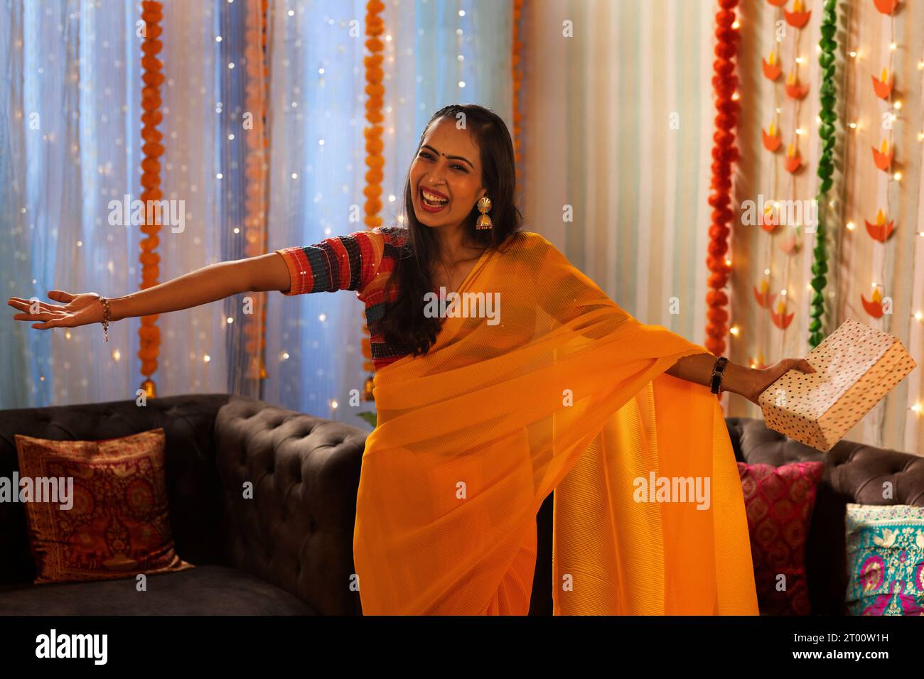 Porträt einer fröhlichen Frau, die mit Geschenk aus Anlass von Diwali steht Stockfoto