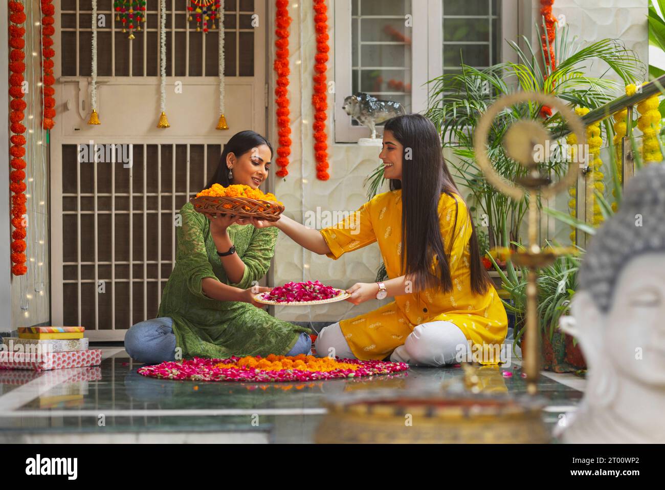 Zwei Schwester, die zu Hause eine Rangola aus Blumen anläßlich von Diwali herstellt Stockfoto