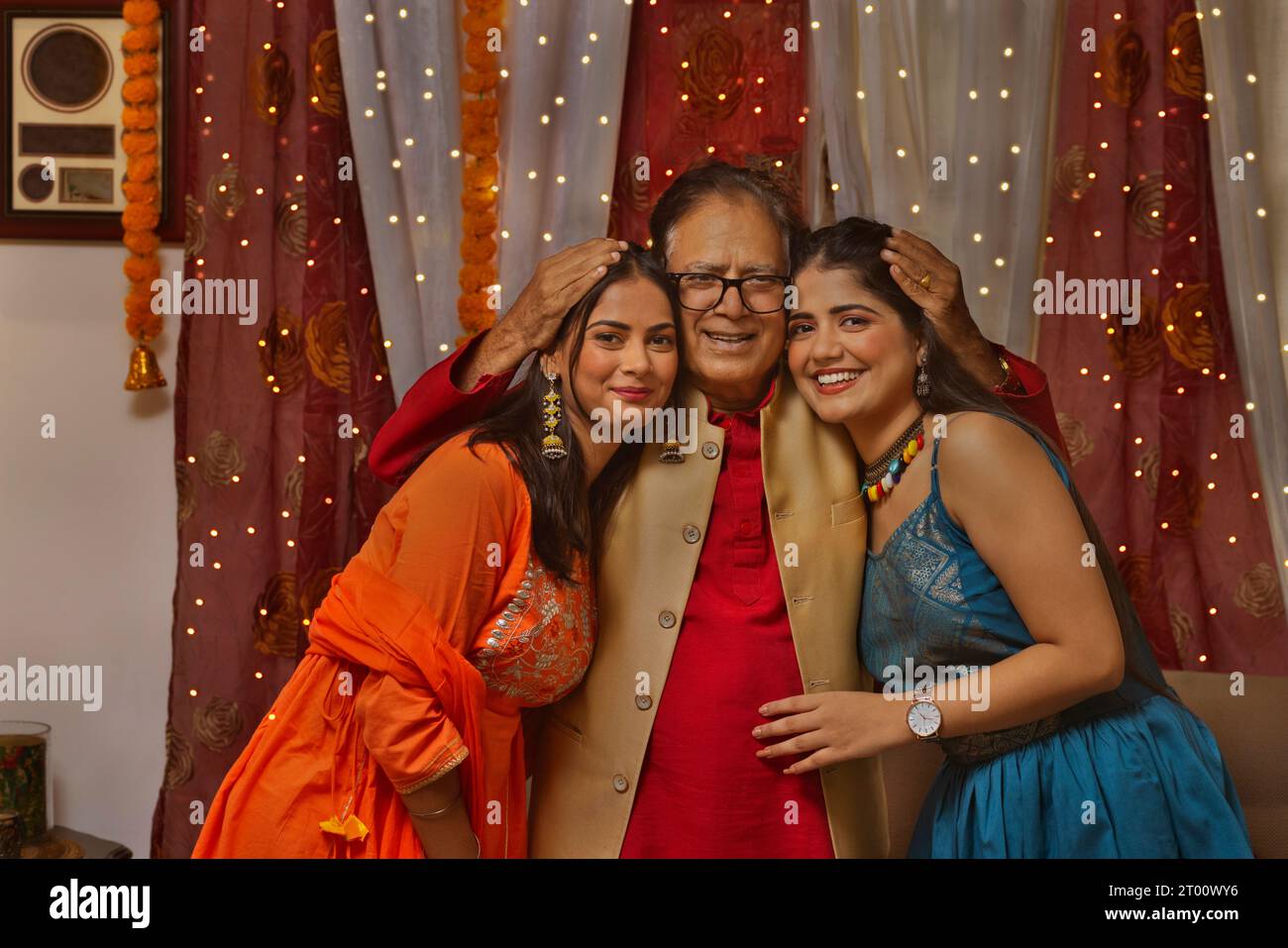 Porträt des Großvaters mit seinen Enkelinnen zu Hause anlässlich von Diwali Stockfoto